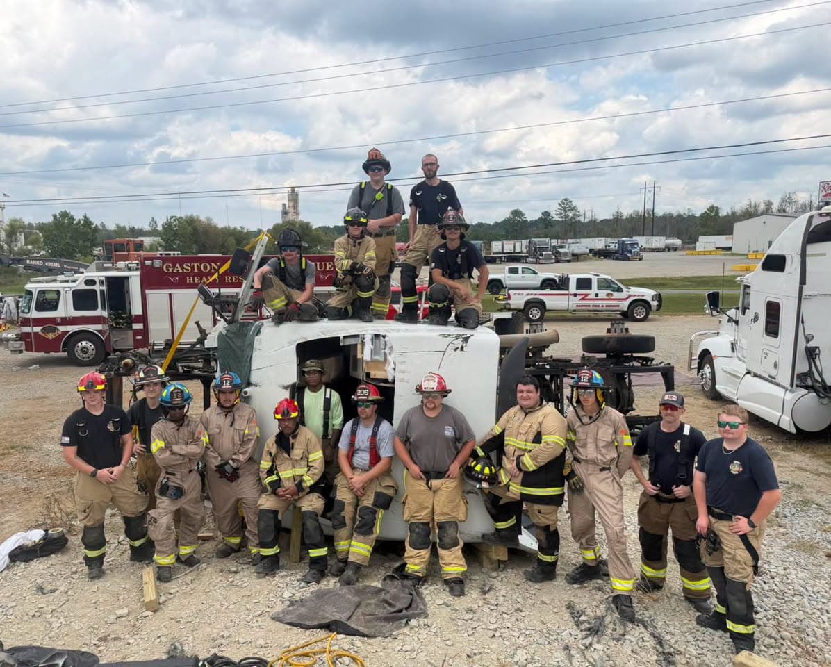 Firefighters from Gaston and nearby departments gathered around a tractor cab on its side after heavy vehicle rescue training