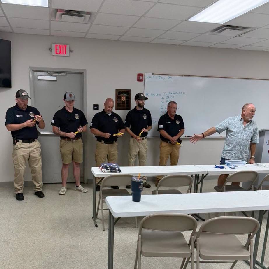 Five Gaston divers holding yellow knots while their instructor speaks beside them