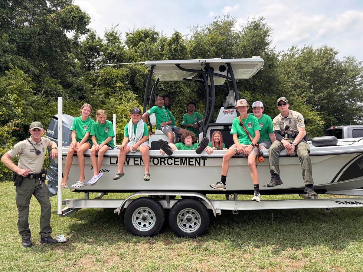 Campers gather on a wildlife patrol boat with officers
